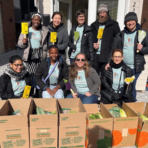 The CHIRP research team poses next to boxes of fresh produce while volunteering.